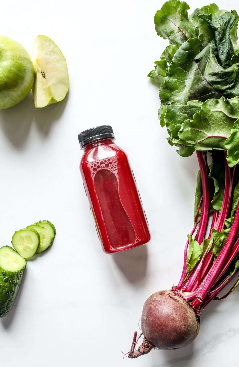  Red Juice in Bottle Beside Beetroot, Apple and Sliced Cucumber